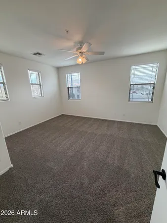 an empty room with windows and fan