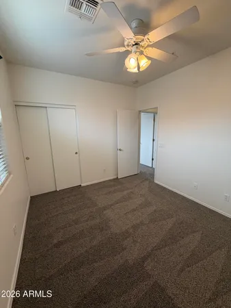 a view of an empty room and a chandelier fan