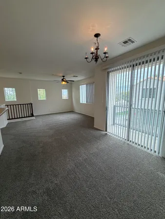 a view of a livingroom with a chandelier fan and windows