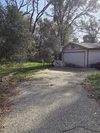 a view of backyard of house and trees