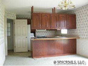 1942 Coopers Gap Road Mill Spring, NC 28756 - Photo 9 of 12 a kitchen with granite countertop a refrigerator and a stove