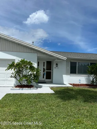 a front view of a house with a garden and yard