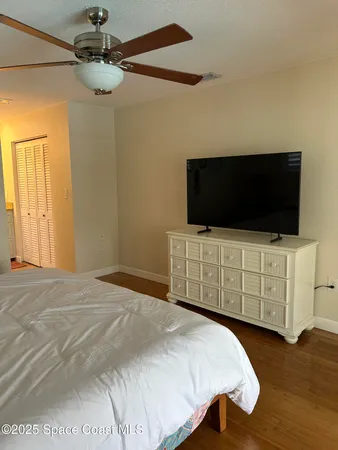 a bedroom with a bed and wooden floor