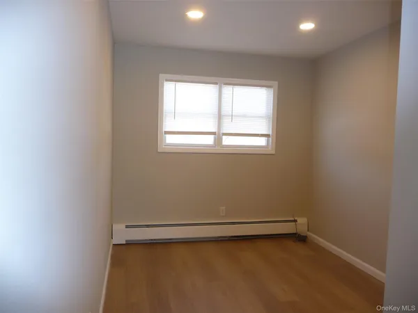 an empty room with a window and ceiling fan