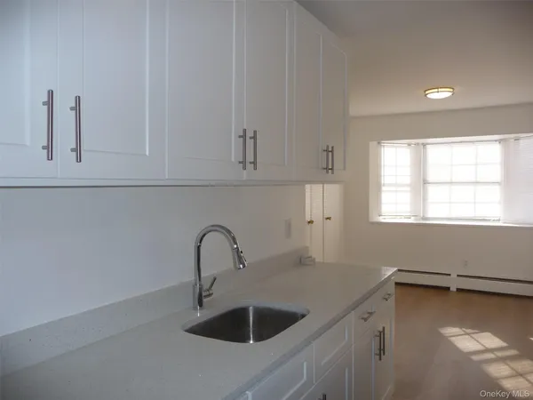 a kitchen with white cabinets and refrigerator