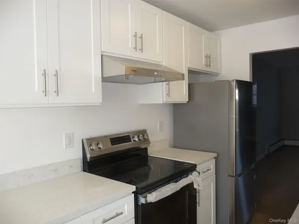 a kitchen with stainless steel appliances granite countertop a sink and dishwasher with white cabinets