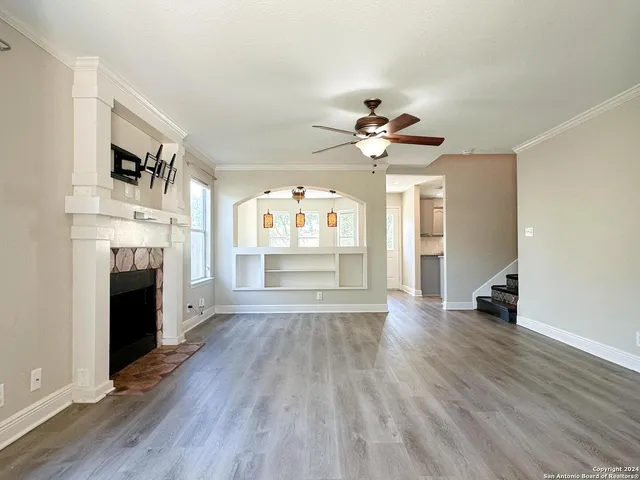 a view of an empty room with a fireplace and a window