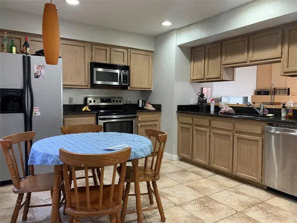a kitchen with granite countertop a sink appliances and cabinets