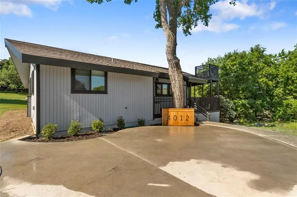 a view of a house with backyard and trees