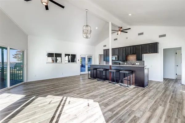 a kitchen with kitchen island a stove a refrigerator cabinets a sink and a stove
