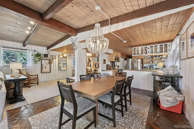 a dining room with wooden floor a chandelier a wooden table and chairs
