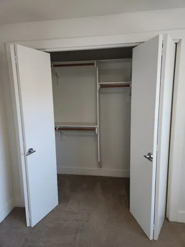 a view of walk in closet with empty racks