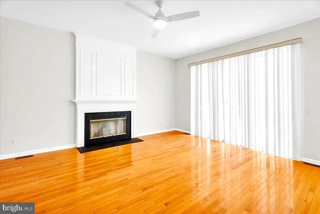 a view of an empty room with a fireplace and a window