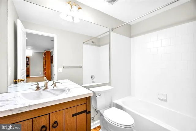 a bathroom with a sink a toilet a mirror and bathtub