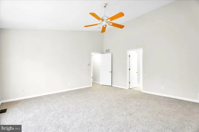 a view of a room with a ceiling fan and a window
