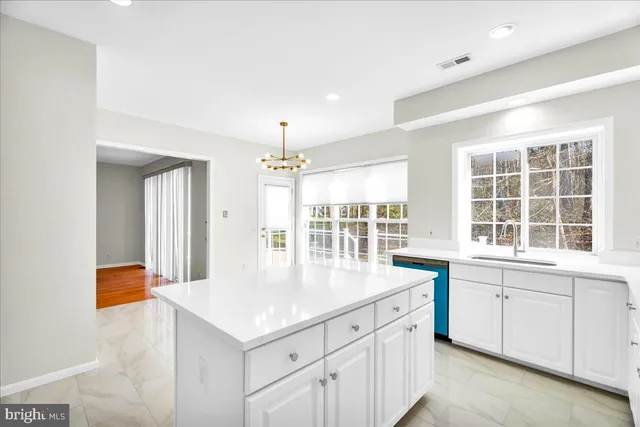 a kitchen with a stove a sink and chandelier