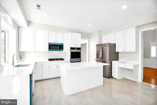 a kitchen with stainless steel appliances a refrigerator stove microwave and sink