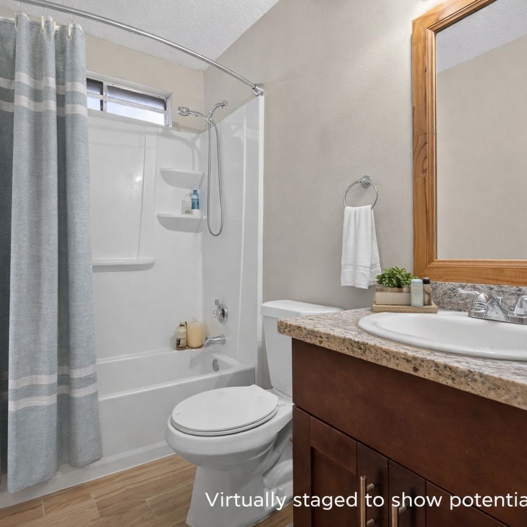 11803 Inga Lane Houston, TX 77064 - Photo 36 of 39 This is a compact, well-lit bathroom with a shower-tub combo, modern fixtures, and a granite countertop. The neutral tones and wooden accents create a cozy atmosphere.