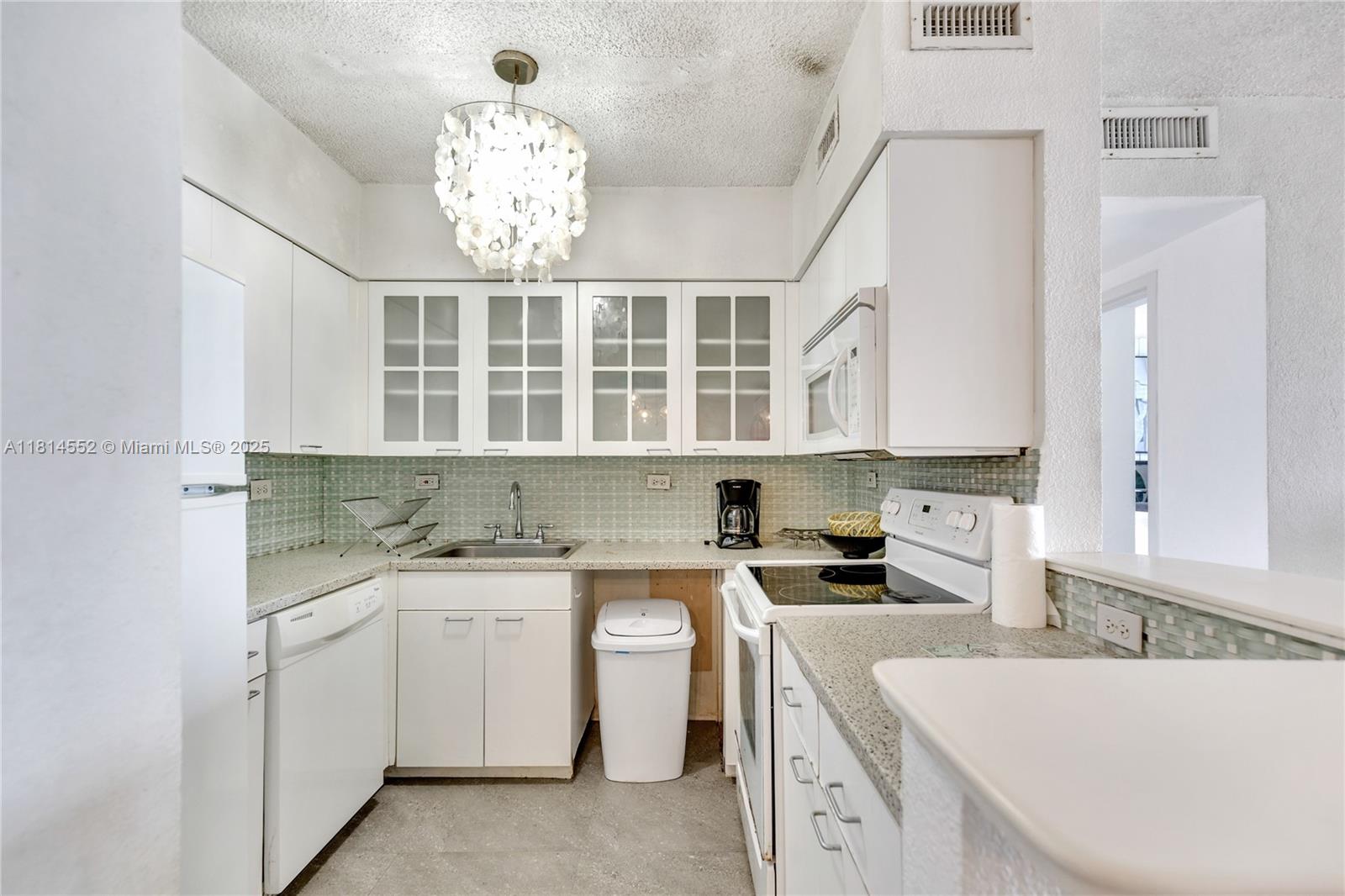 1500 Bay Road, Unit 830S Miami Beach, FL 33139 - Photo 14 of 20 a kitchen that has a lot of cabinets in it