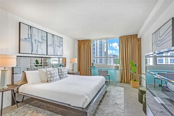 a bedroom with a bed a bookshelf and a large window