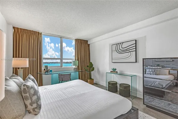 a bedroom with a bed and a dresser with mirror