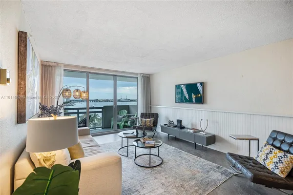a living room with furniture and view of kitchen