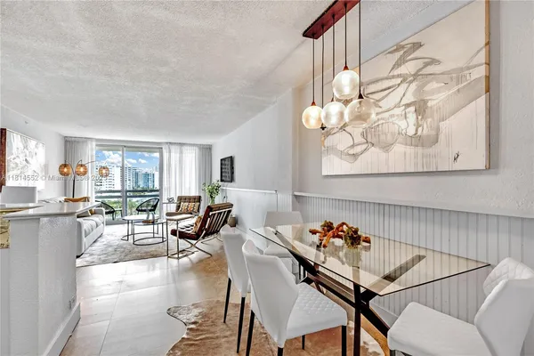 a living room with furniture a chandelier and a table
