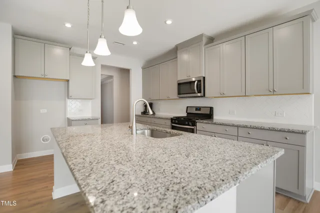 a kitchen with granite countertop a sink a counter top space appliances and cabinets