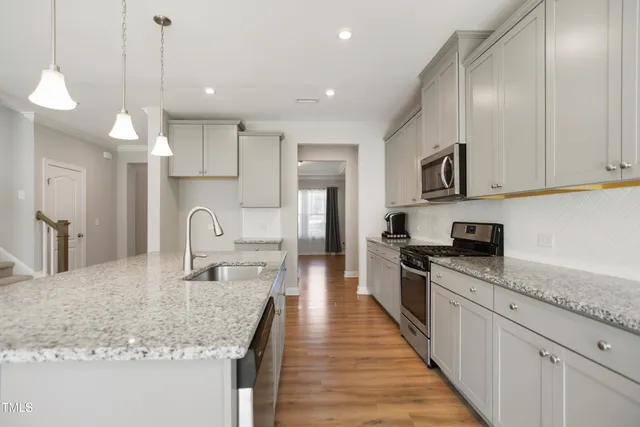 a large kitchen with stainless steel appliances granite countertop a lot of counter space a sink and a refrigerator