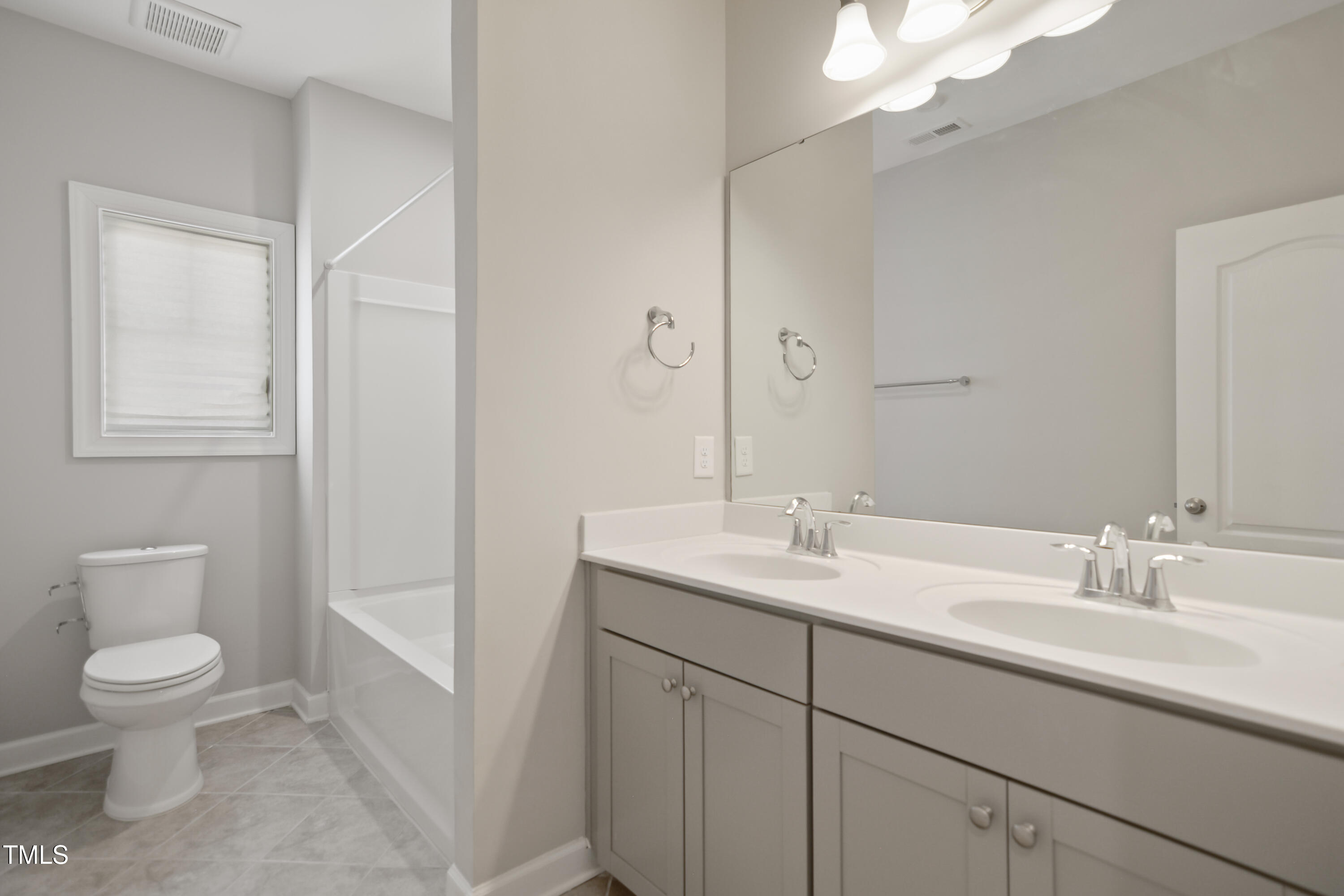 917 Lippincott Road Durham, NC 27703 - Photo 25 of 30 a bathroom with a toilet a sink a mirror a vanity and window