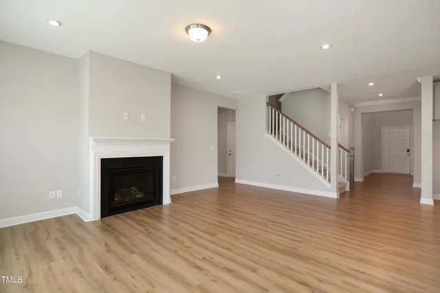 a view of empty room with wooden floor and fireplace