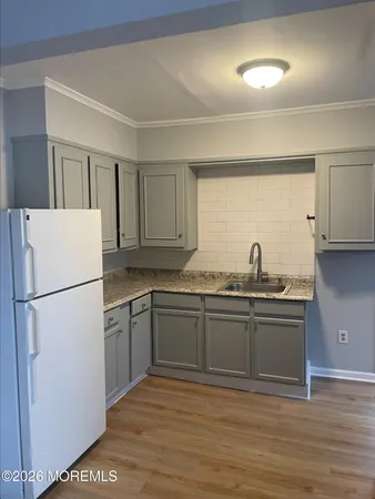 a kitchen with stainless steel appliances granite countertop a refrigerator sink and white cabinets