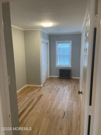 a view of a room with wooden floor and window