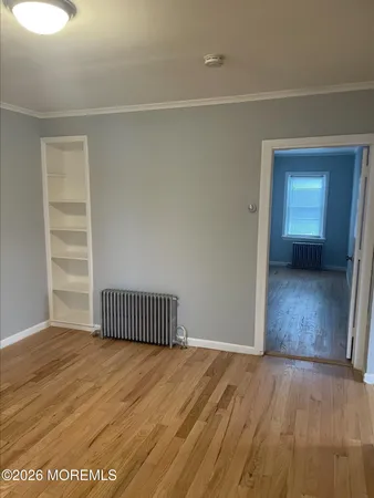 a view of a room with wooden floor and a window