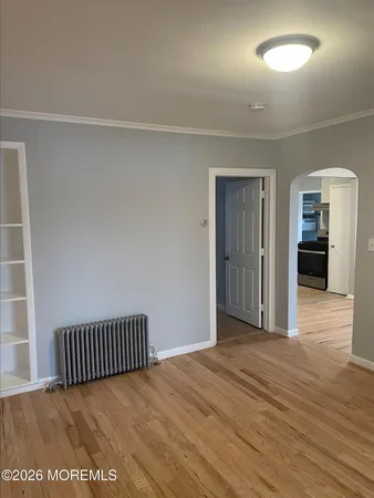 an empty room with wooden floor and bathroom