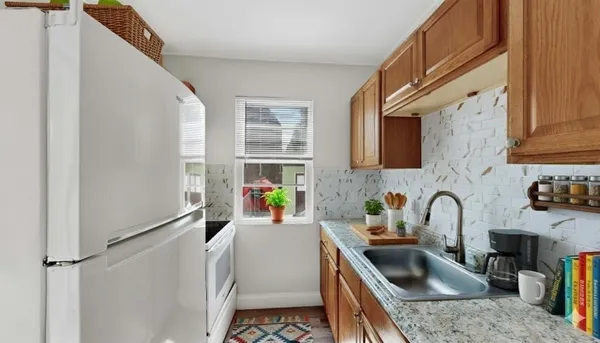 a kitchen with granite countertop a sink a counter top space and stainless steel appliances