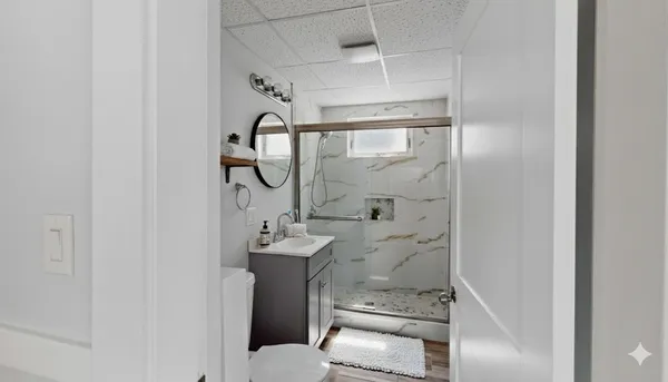 a bathroom with a granite countertop sink toilet and shower