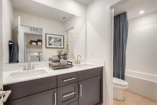 a bathroom with a toilet a sink a mirror and a shower