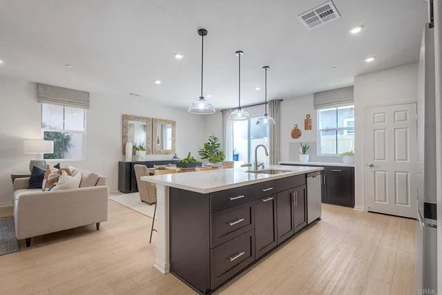 a kitchen with kitchen island granite countertop a sink and a stove top oven