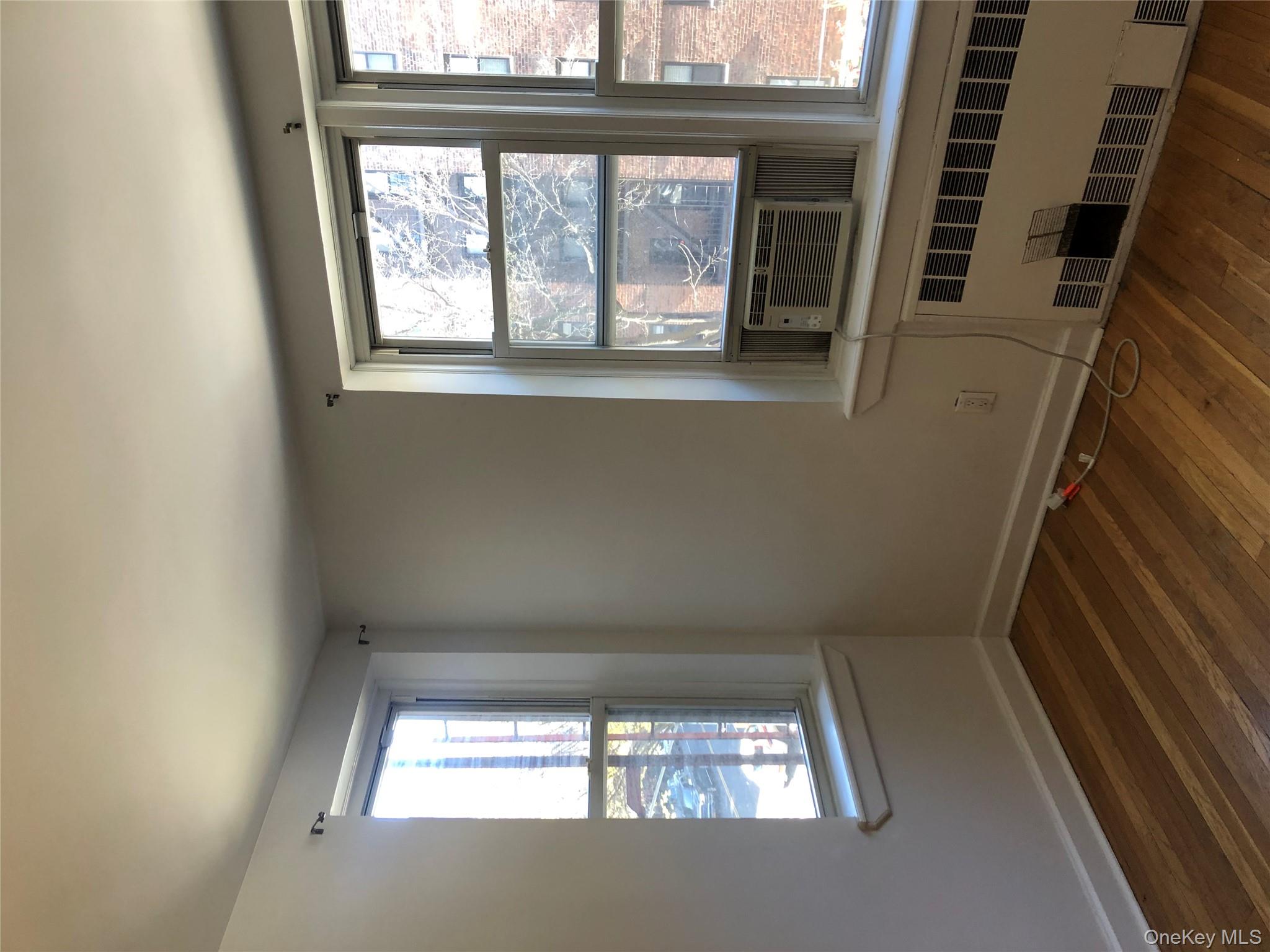 66-33 Yellowstone Boulevard, Unit 2B Queens, NY 11375 - Photo 11 of 13 a view of an empty room with wooden floor and a window