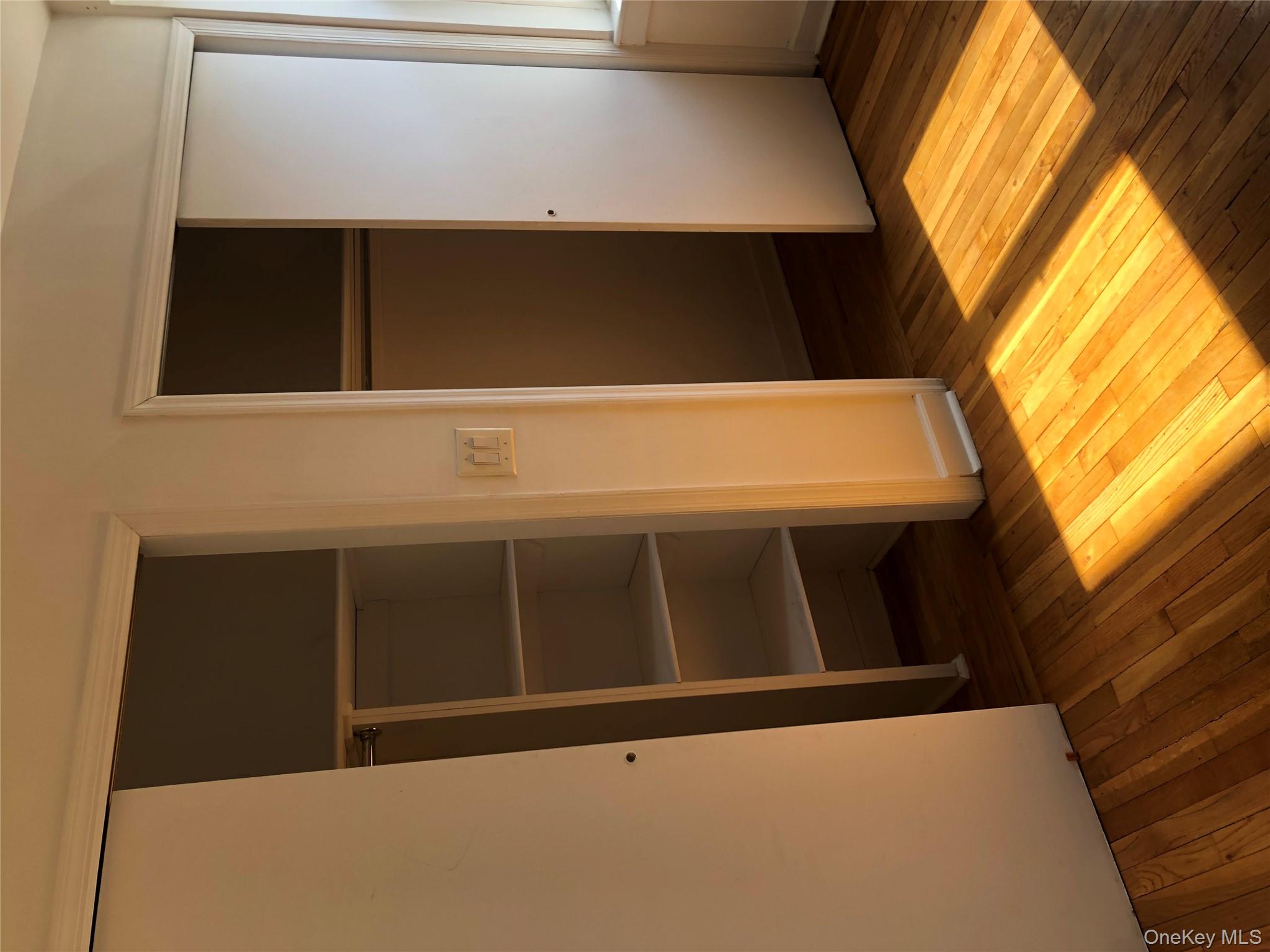 66-33 Yellowstone Boulevard, Unit 2B Queens, NY 11375 - Photo 6 of 13 a view of an empty room with wooden floor and closet