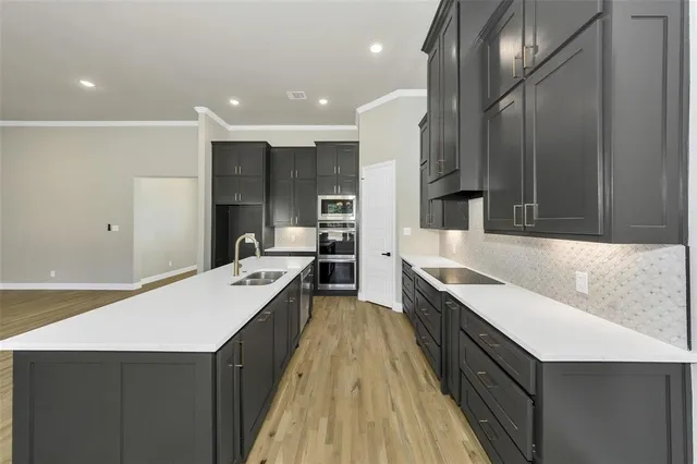 a large kitchen with sink cabinets and stainless steel appliances