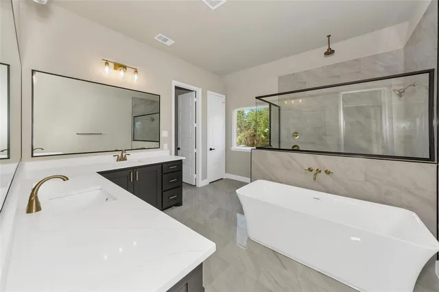 a spacious bathroom with a bathtub sink and mirror
