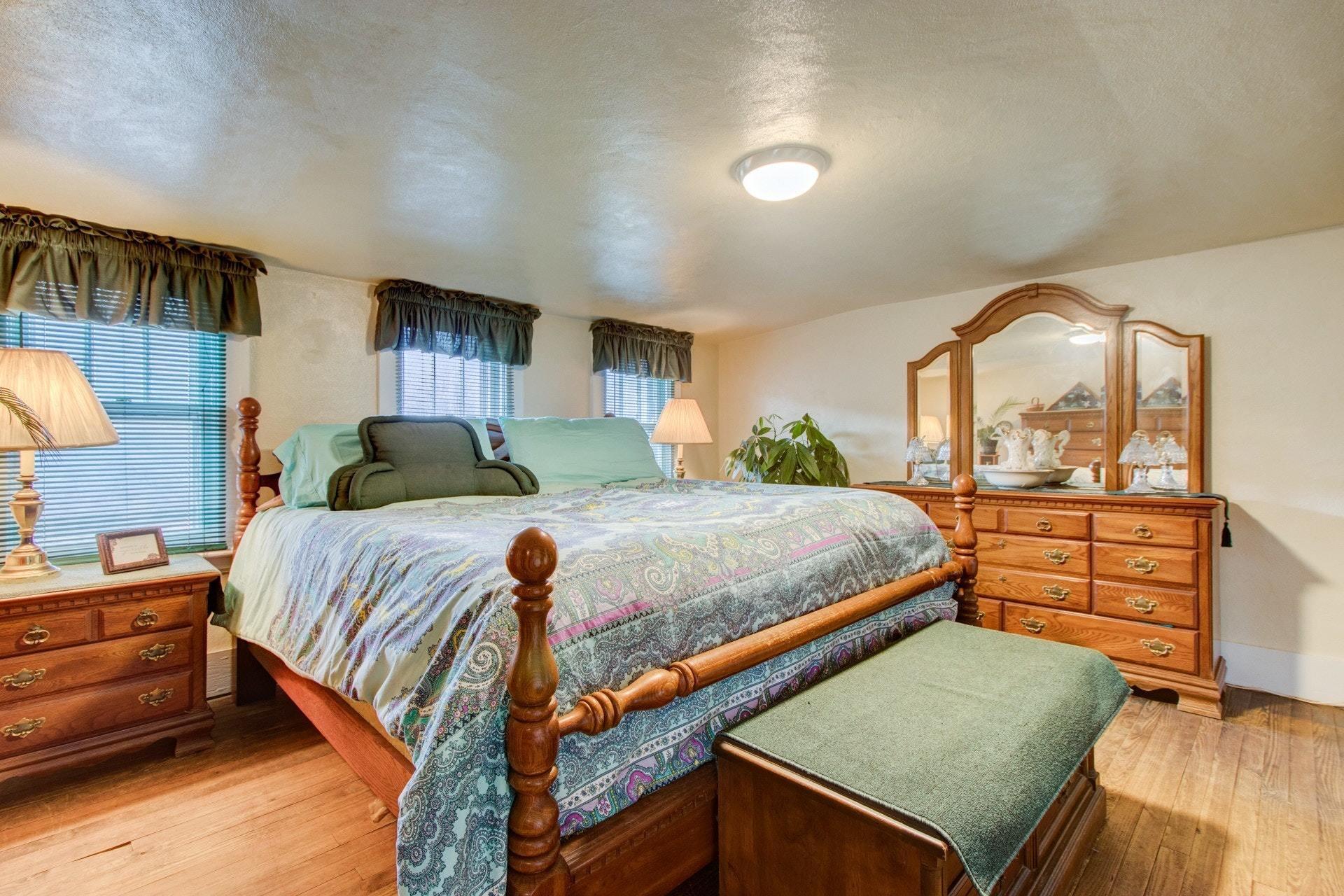 296 Archway Road Blue Ridge, VA 24064 - Photo 14 of 28 a bedroom with a bed and a dresser next to a window