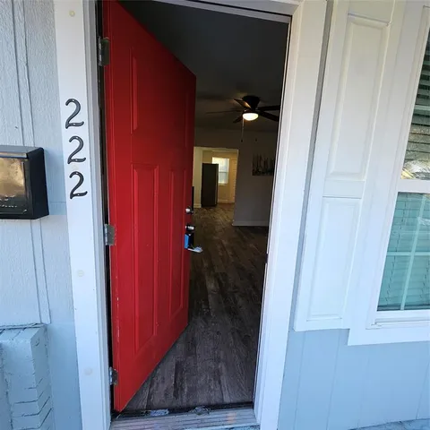 a view of a hallway with wooden floor and closet
