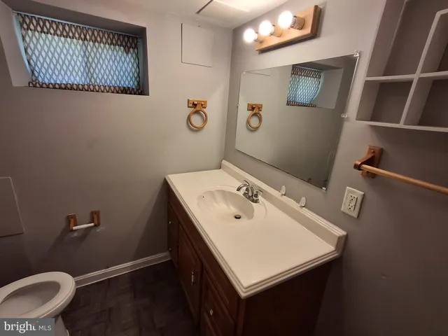 a bathroom with a sink a toilet and a mirror