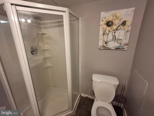 a white toilet sitting next to a shower