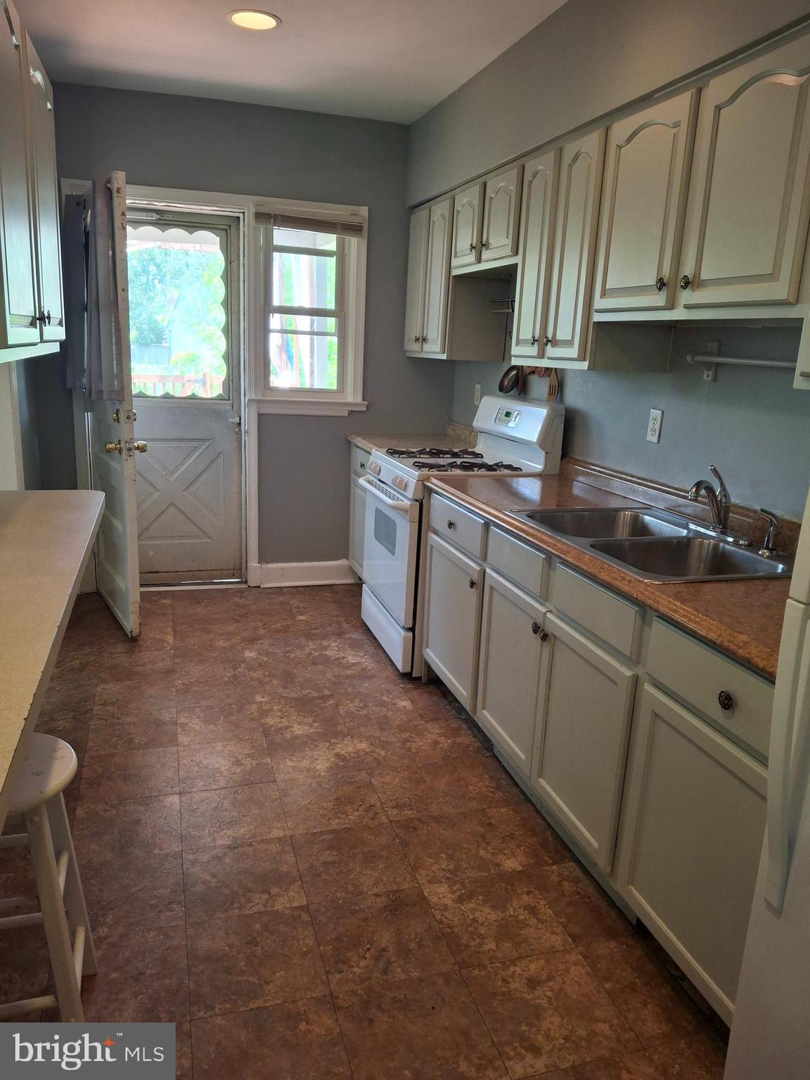 3906 Rosecrest Avenue Baltimore, MD 21215 - Photo 7 of 23 a kitchen with stainless steel appliances granite countertop a sink stove and cabinets