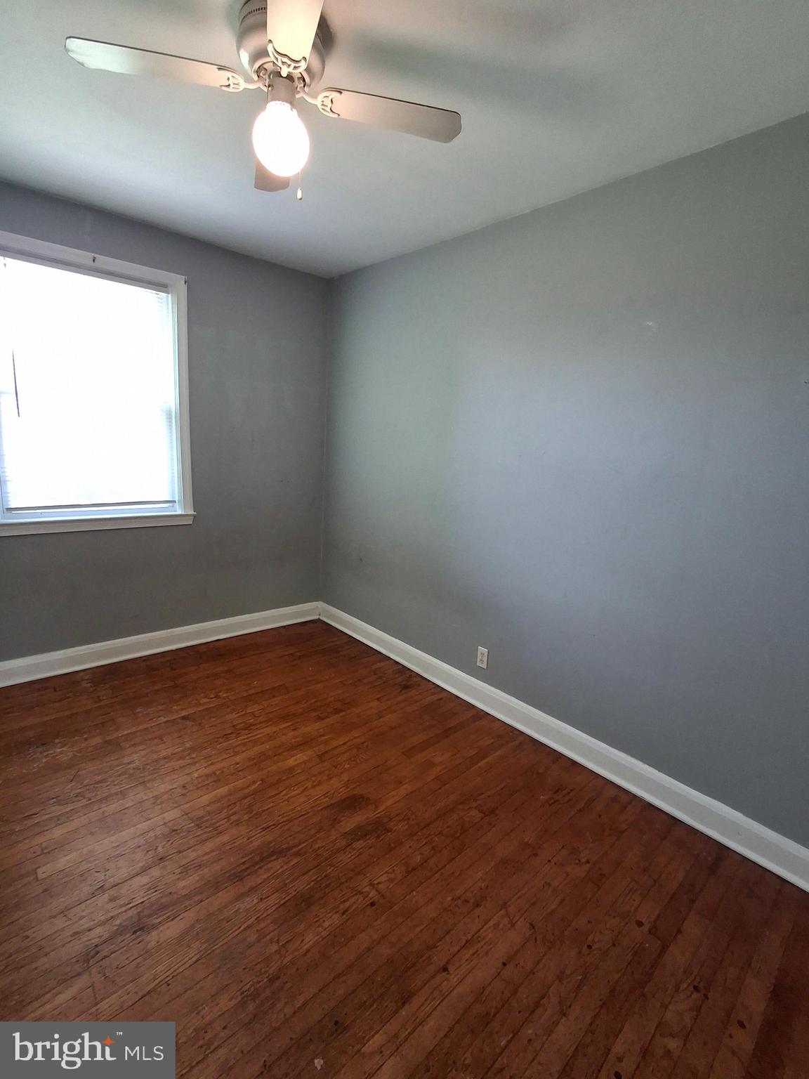3906 Rosecrest Avenue Baltimore, MD 21215 - Photo 10 of 23 an empty room with wooden floor and windows