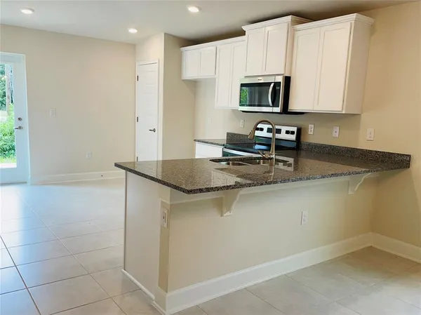 a kitchen with a sink a microwave and cabinets